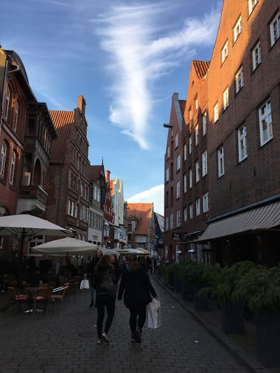 A charming European street with colorful buildings and cobblestone pavement under a bright blue sky.