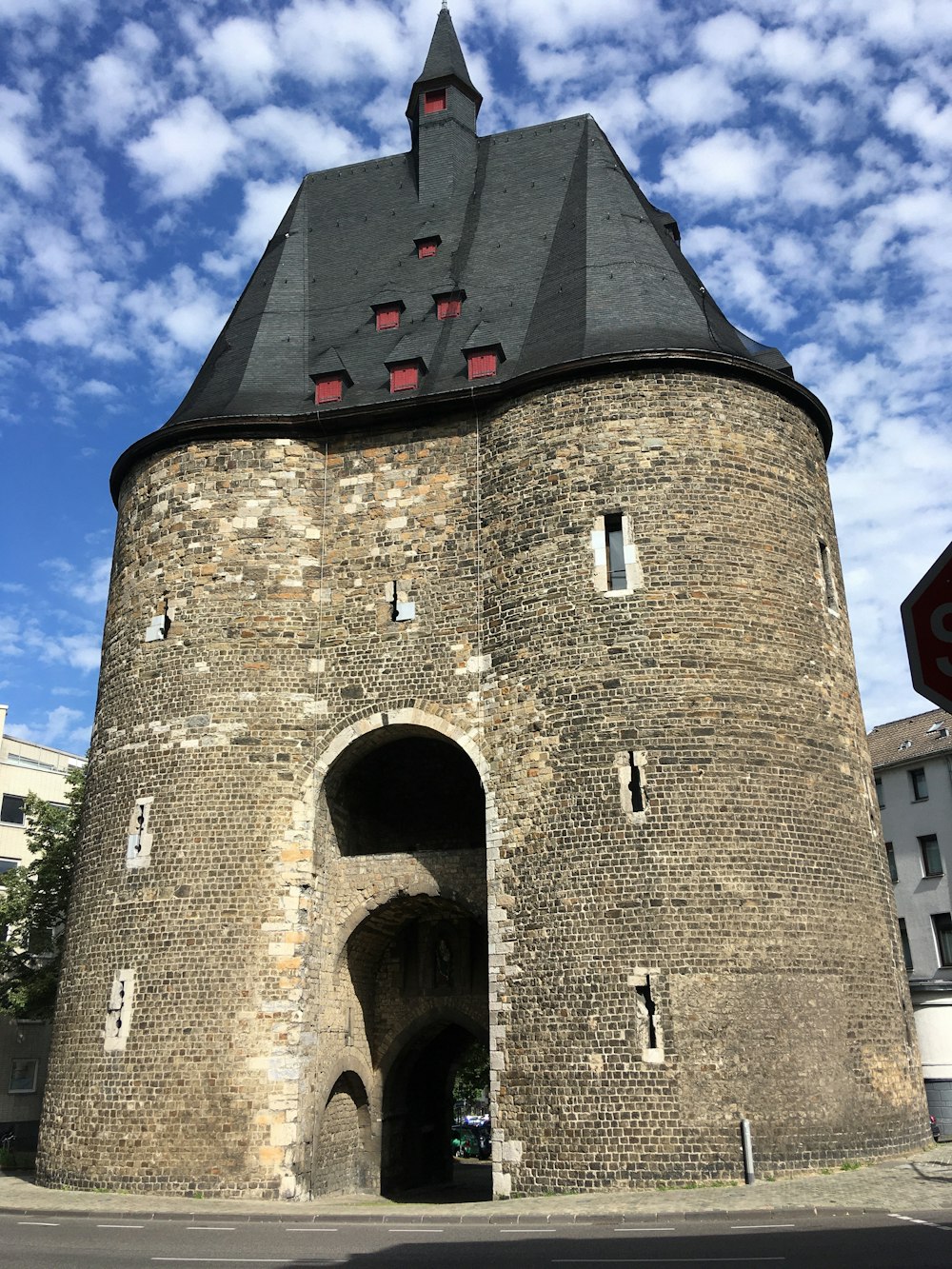 a tall brick building with a black roof