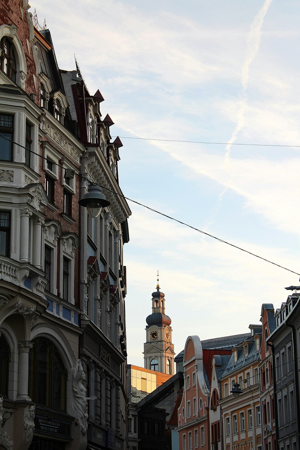 a city street with buildings and a clock tower in the background