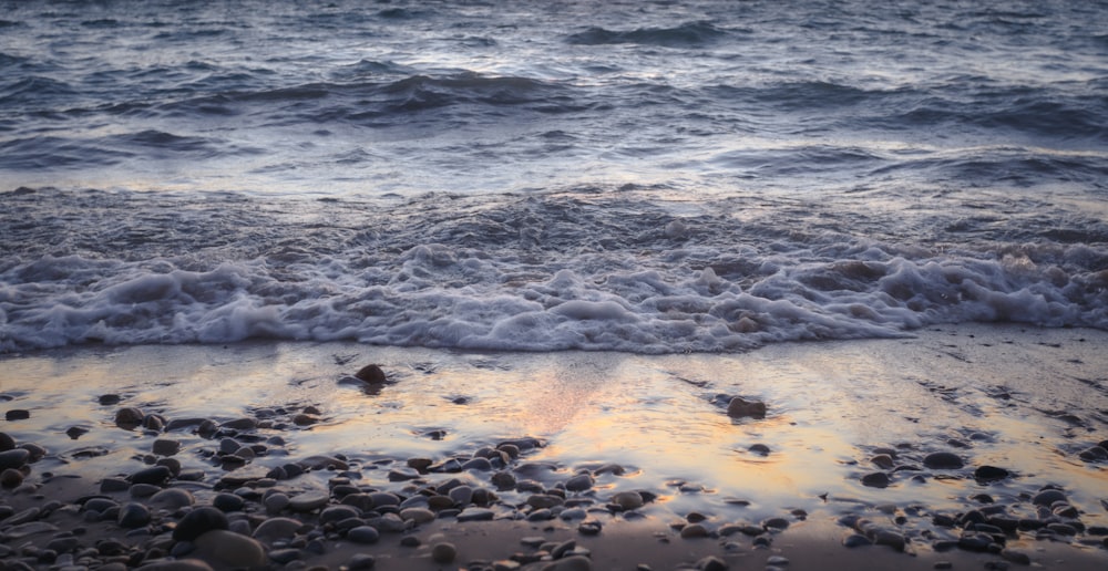 a sandy beach with waves coming in to shore