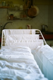 a hospital bed with white sheets in a room