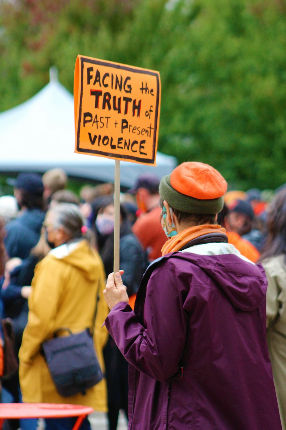 a man holding a sign that says facing the truth