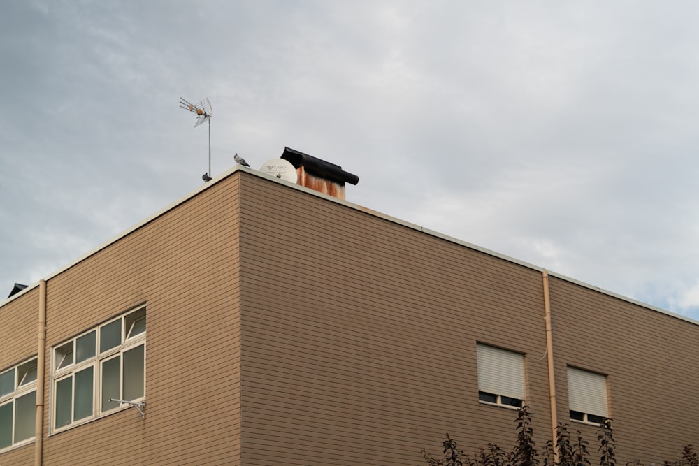 a brown building with a weather vane on top of it
