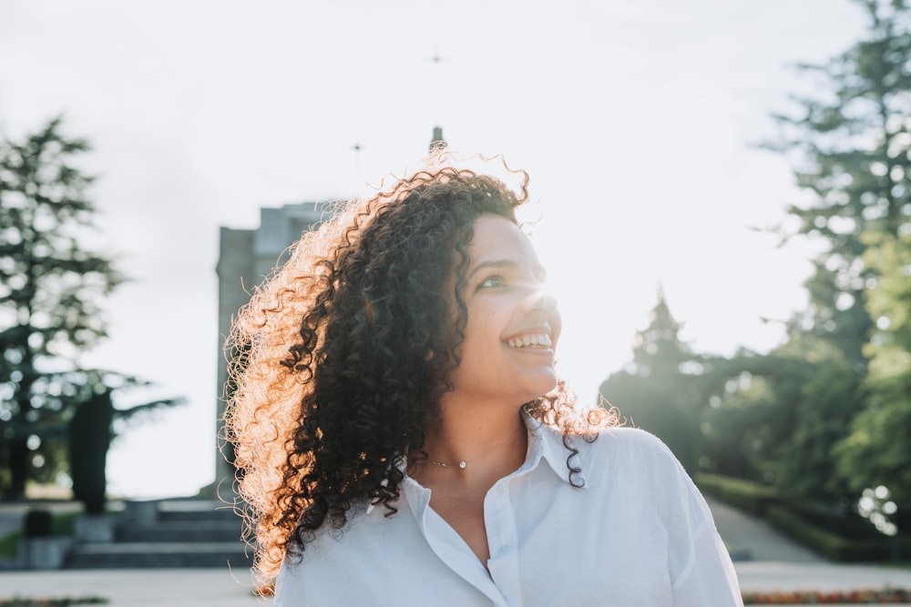 a woman with curly hair smiling at the camera