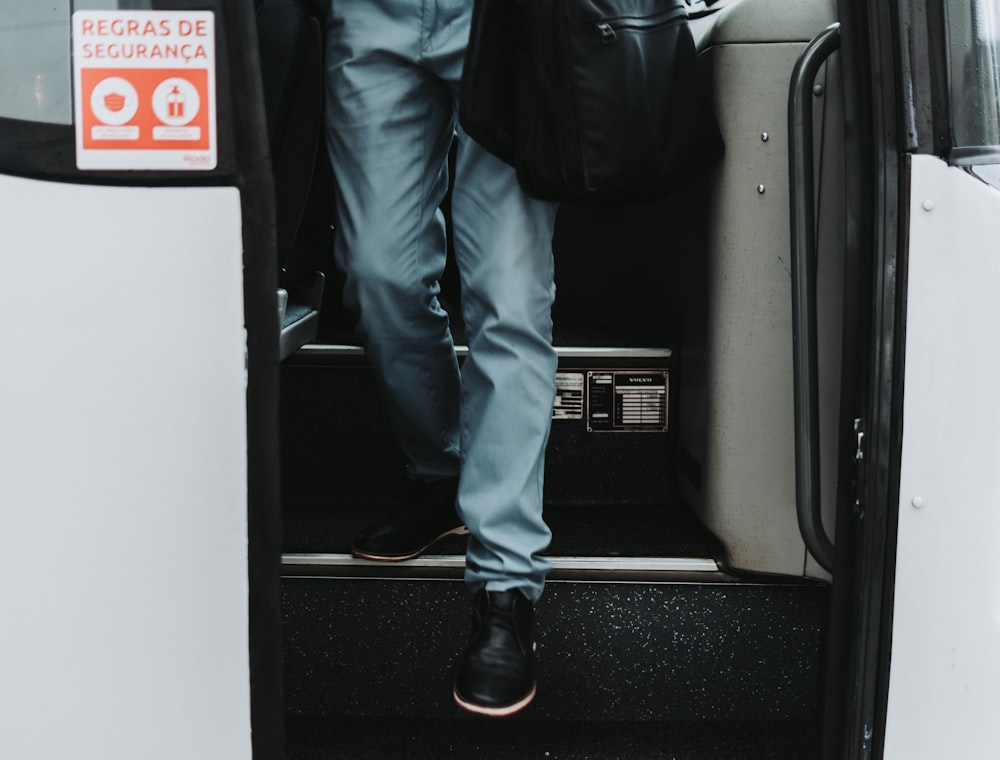 a man with a backpack is stepping out of a bus