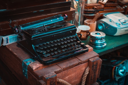 A vintage typewriter with old newspaper clippings scattered around.