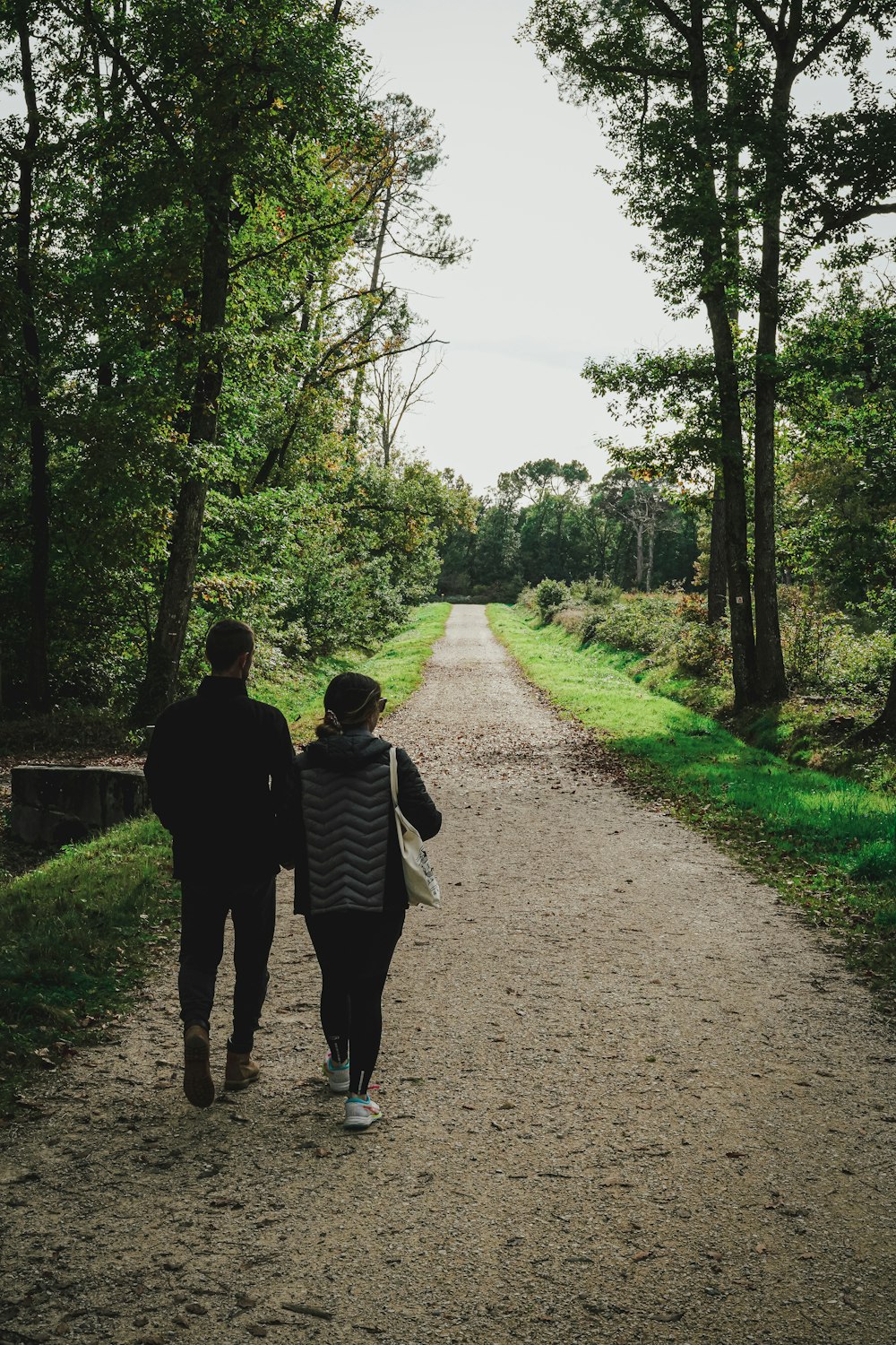 a man and a woman walking down a dirt road