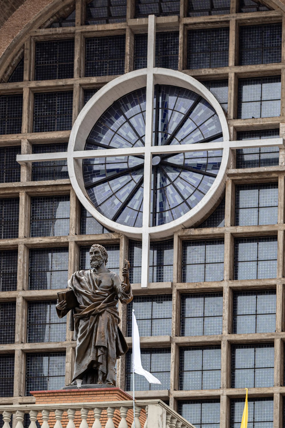 une statue d’un homme avec une croix au sommet d’un bâtiment