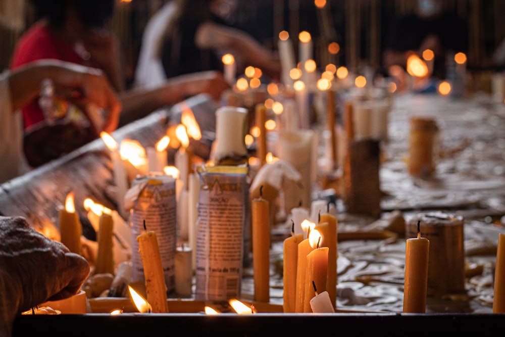 a group of people sitting around a table covered in candles