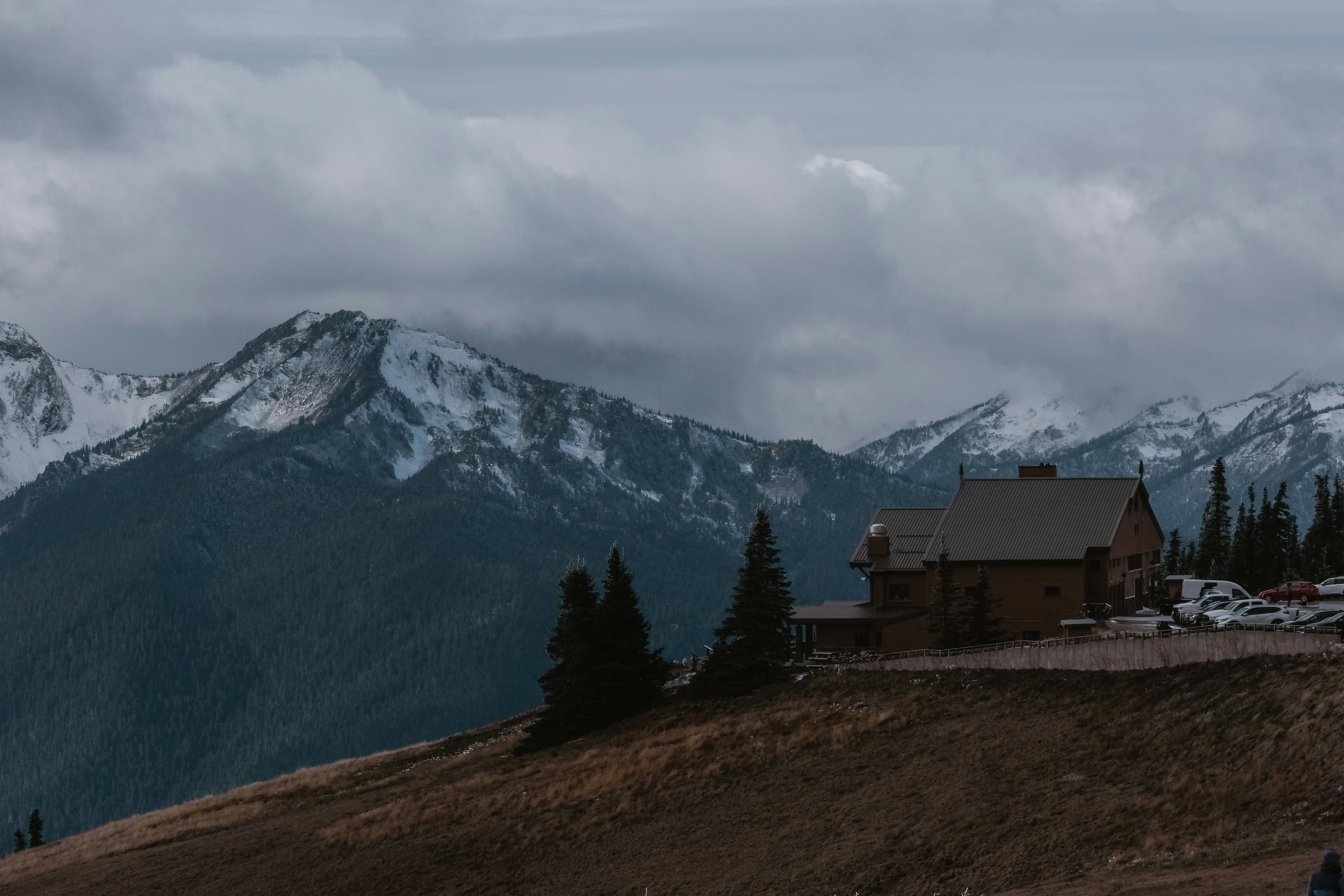 a house on a hill with mountains in the background