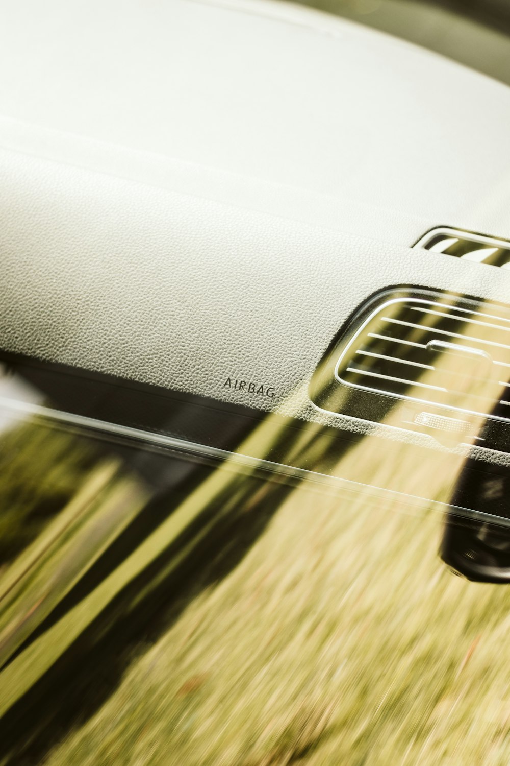 a close up of a car's dashboard with grass in the background