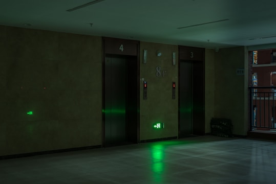 A building manager answering an urgent call late at night in a condo lobby.