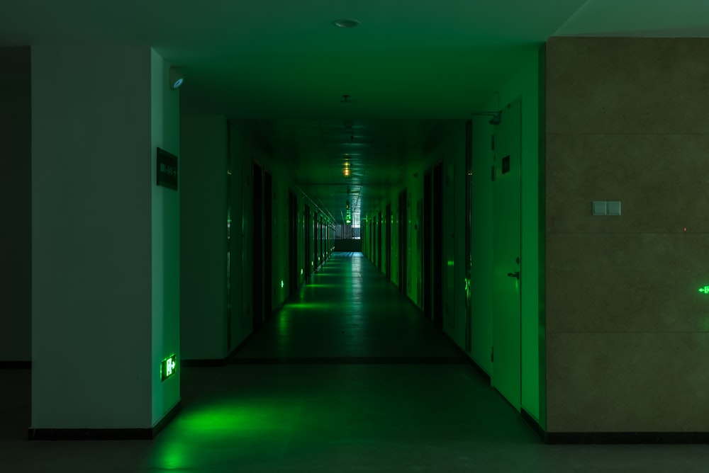 a long hallway with a green light on the wall