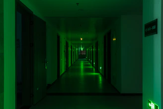 a long hallway with green lights on the walls