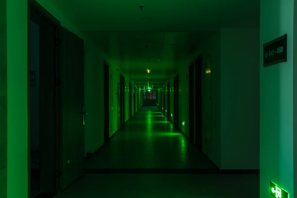 a long hallway with green lights on the walls