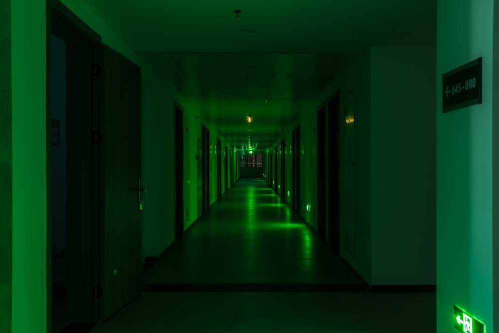 a long hallway with green lights on the walls