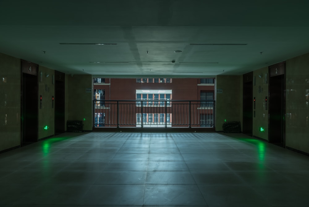an empty room with green lights and a balcony