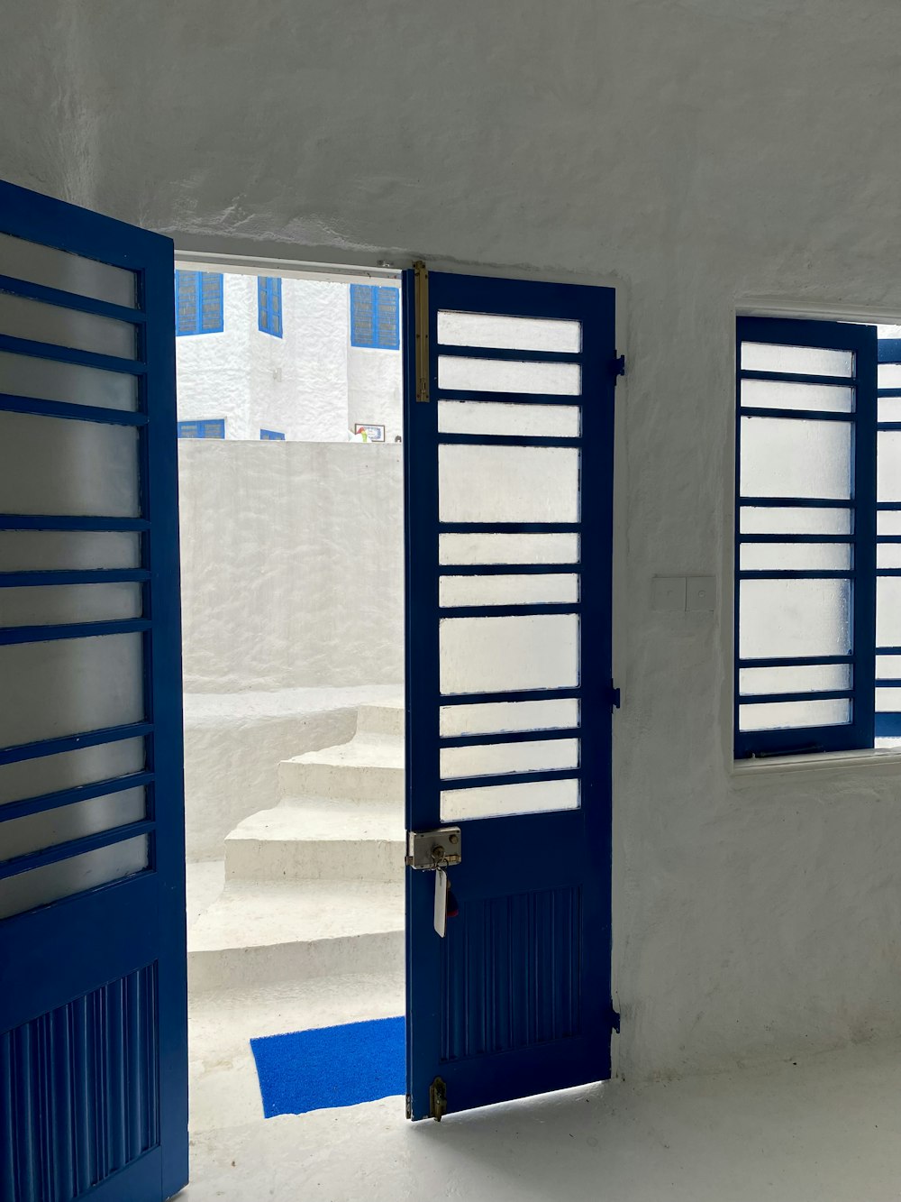 a room with two blue doors and a white wall