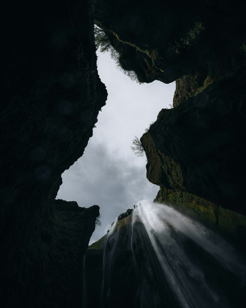 a view of a waterfall from the bottom of a cave