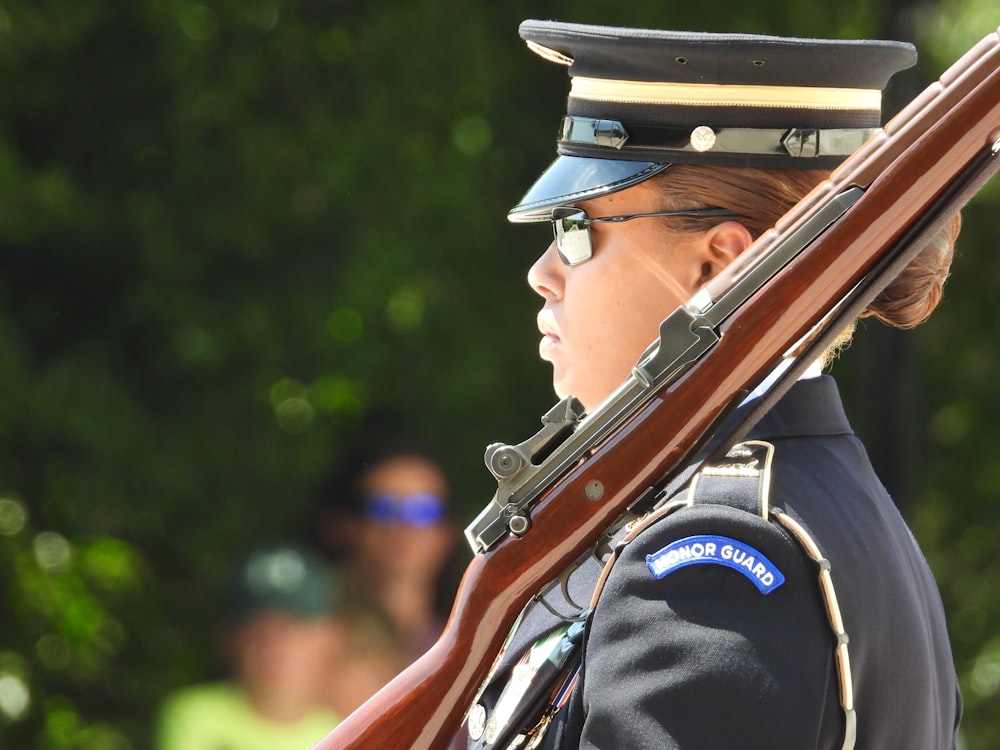 a woman in a uniform holding a rifle