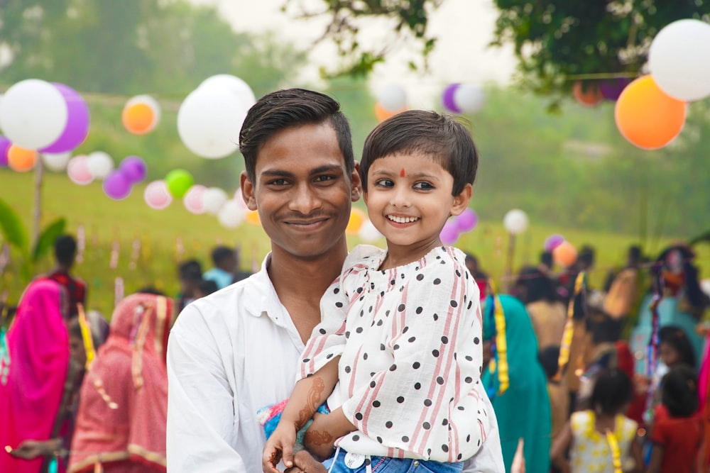 a man holding a child in front of a crowd of people