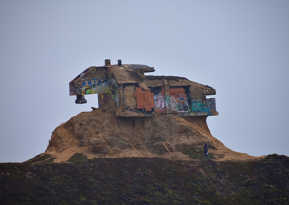 a house on top of a hill covered in graffiti