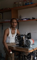 a man standing in front of a sewing machine