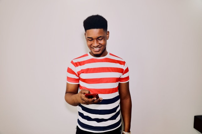 a man in striped shirt holding a cell phone