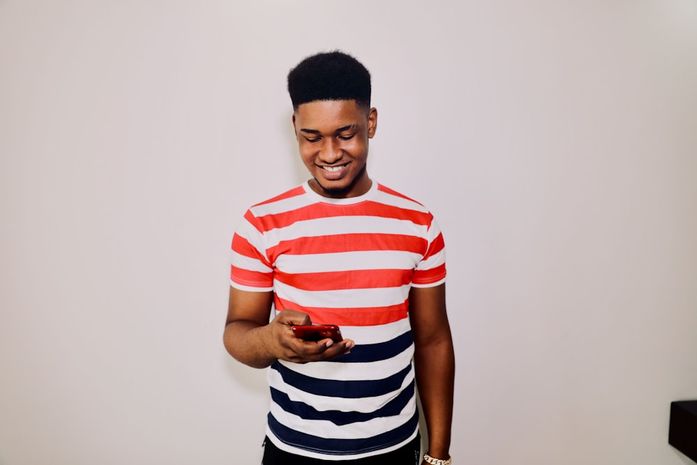 a man in striped shirt holding a cell phone