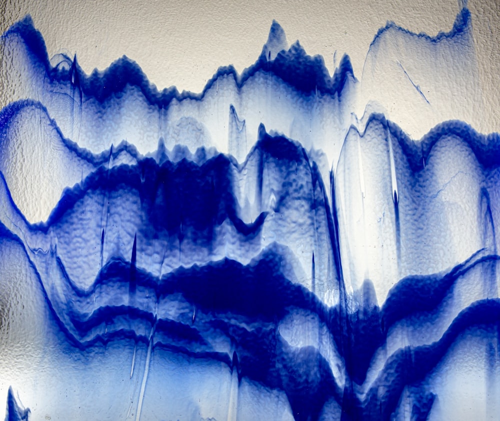 a close up of a blue and white painting on a wall