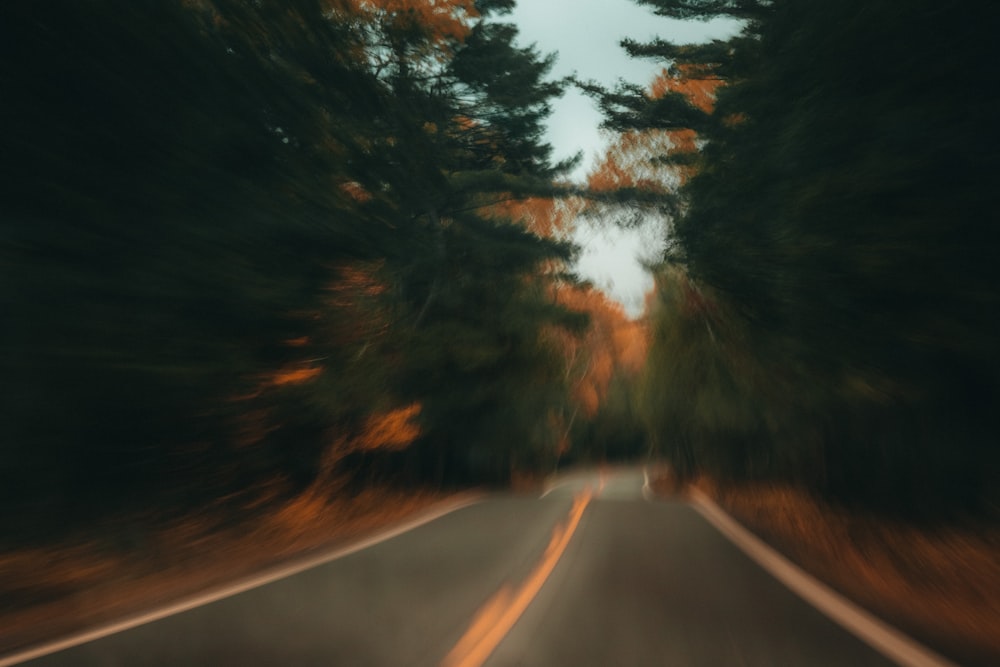 a blurry photo of a road with trees in the background