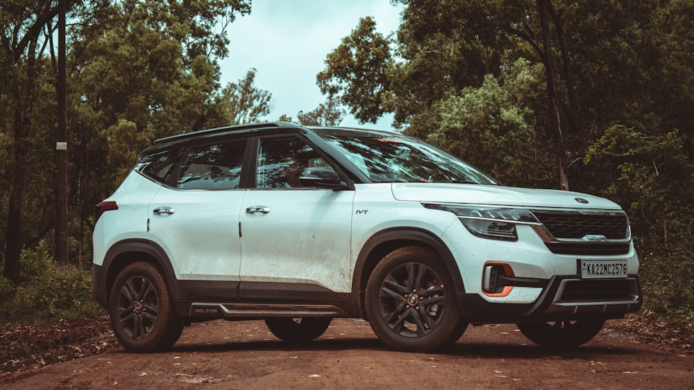 a white suv parked on a dirt road