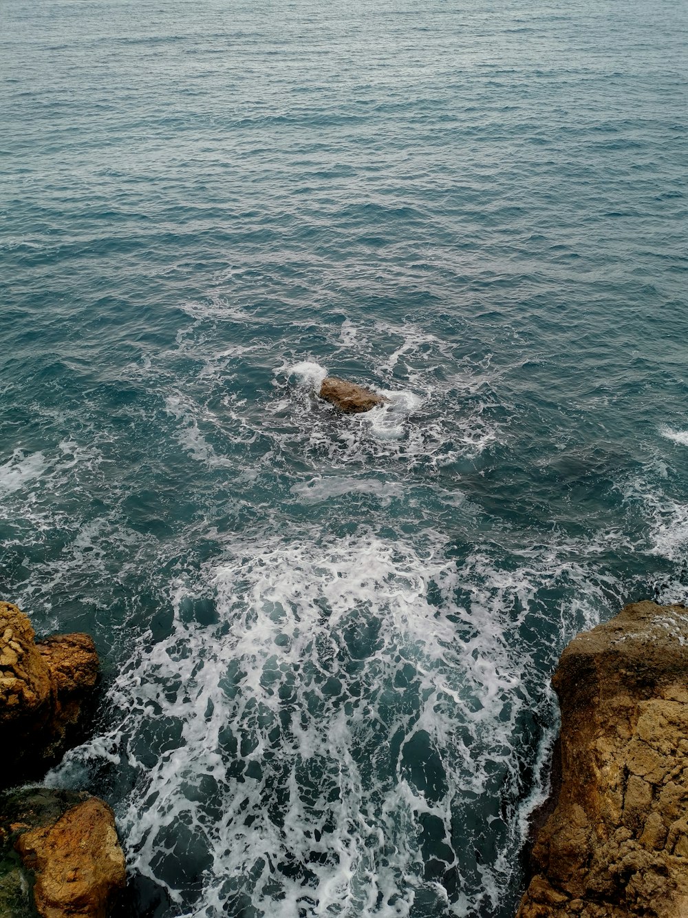 a body of water with rocks in the foreground