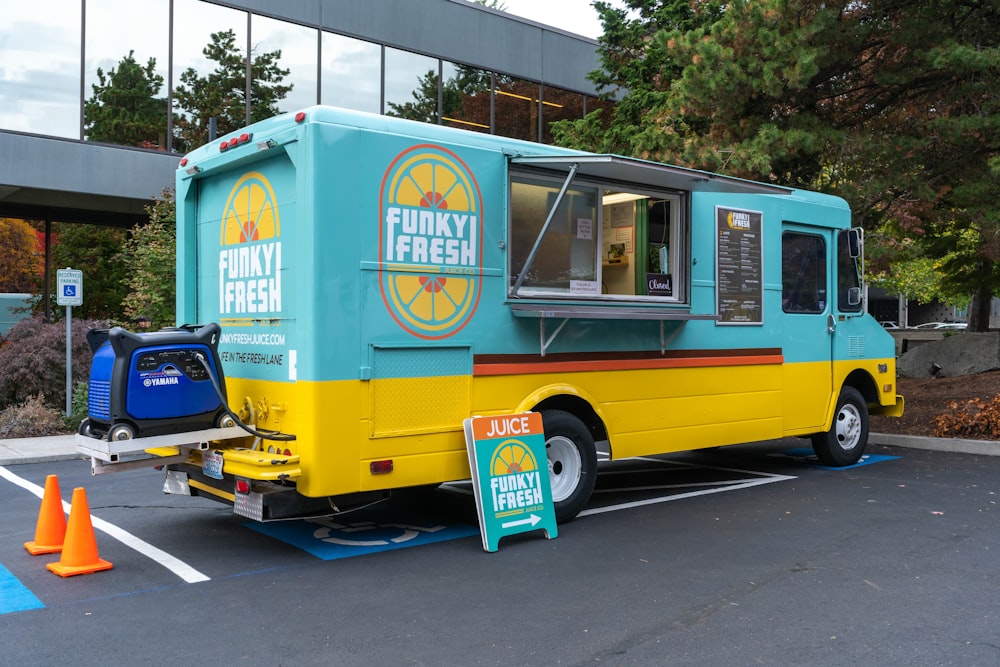 a blue and yellow food truck parked in a parking lot