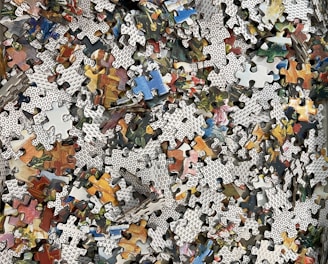 a pile of puzzle pieces sitting on top of a wooden floor