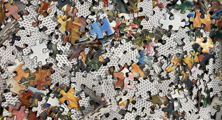 a pile of puzzle pieces sitting on top of a wooden floor