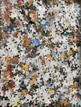 a pile of puzzle pieces sitting on top of a wooden floor