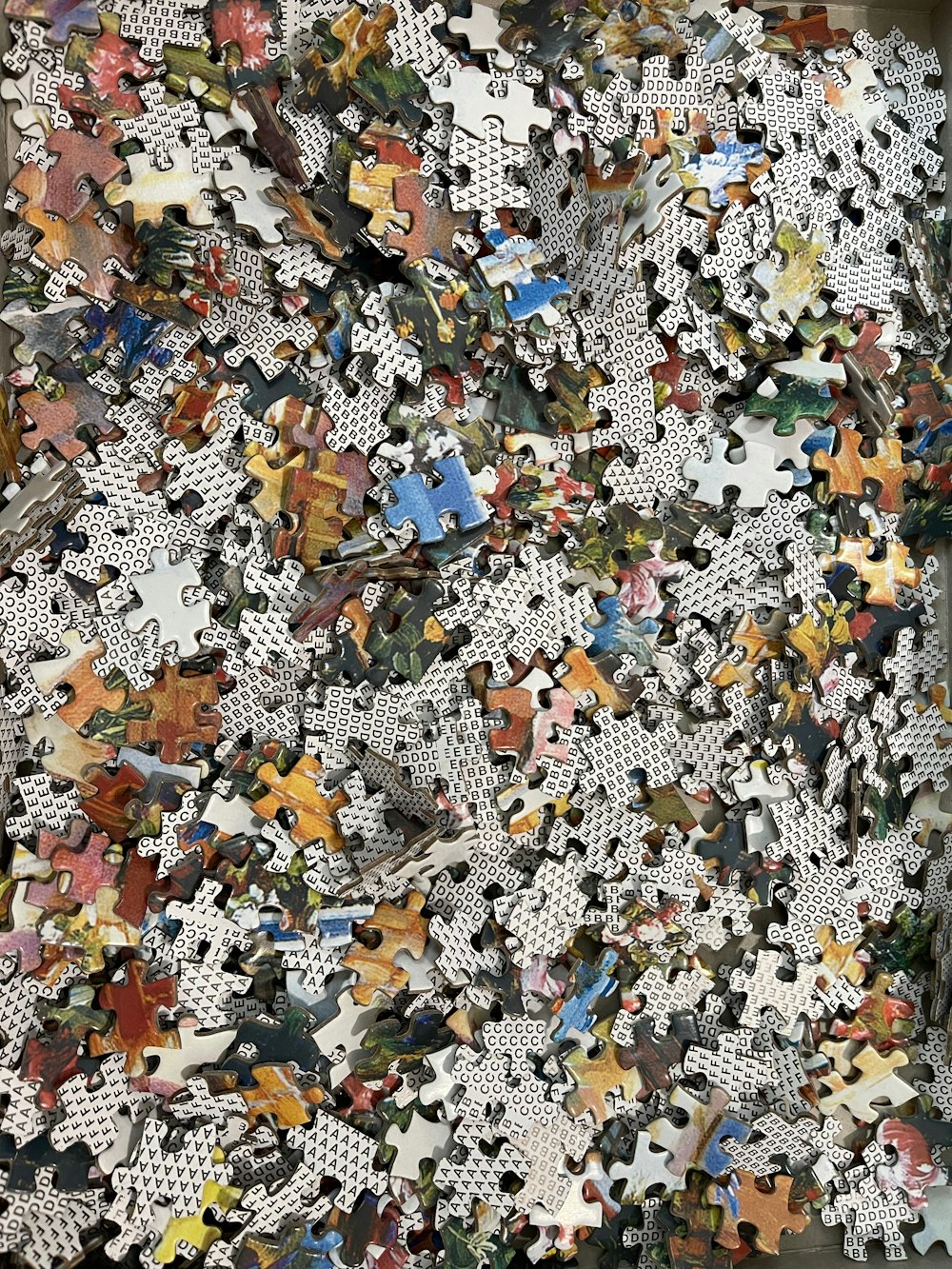 a pile of puzzle pieces sitting on top of a wooden floor