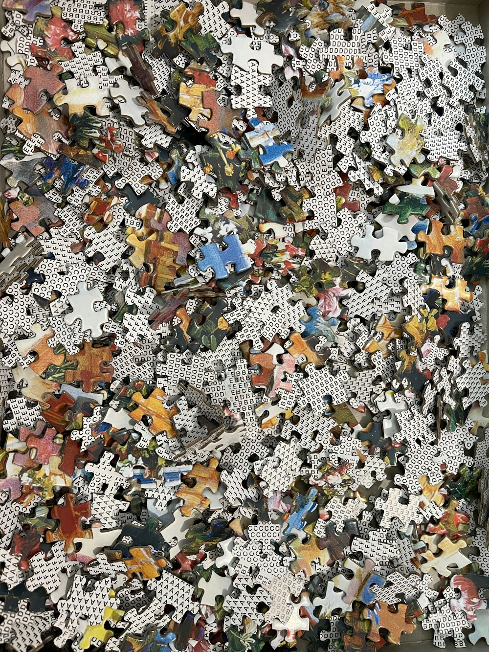 una pila di pezzi di puzzle seduti sopra un pavimento di legno