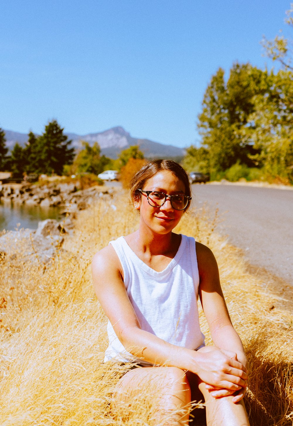 a woman sitting on the side of a road