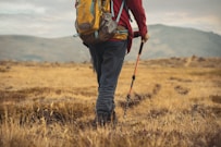 a man with a backpack walking through a field