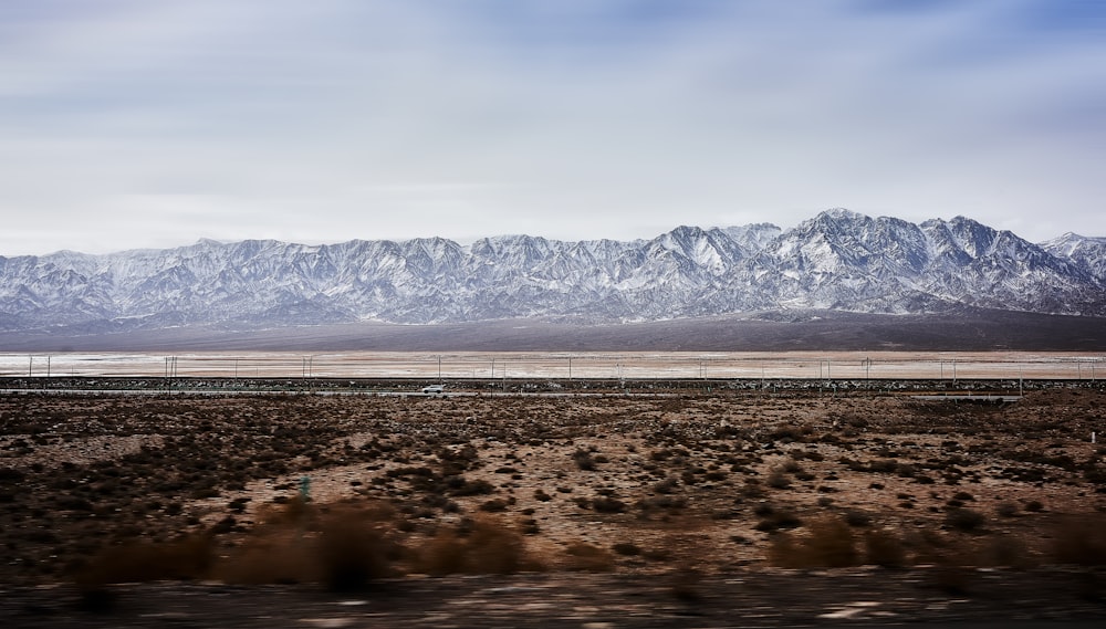 a view of a mountain range from a moving train