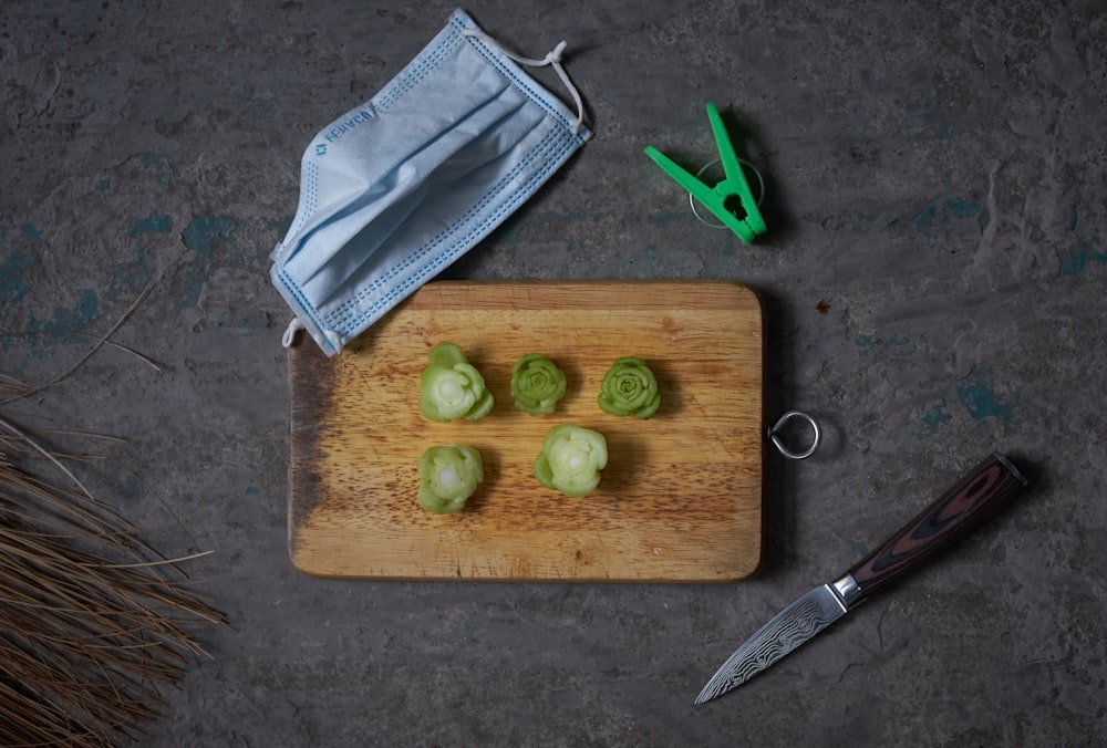 a cutting board topped with green vegetables next to a pair of scissors