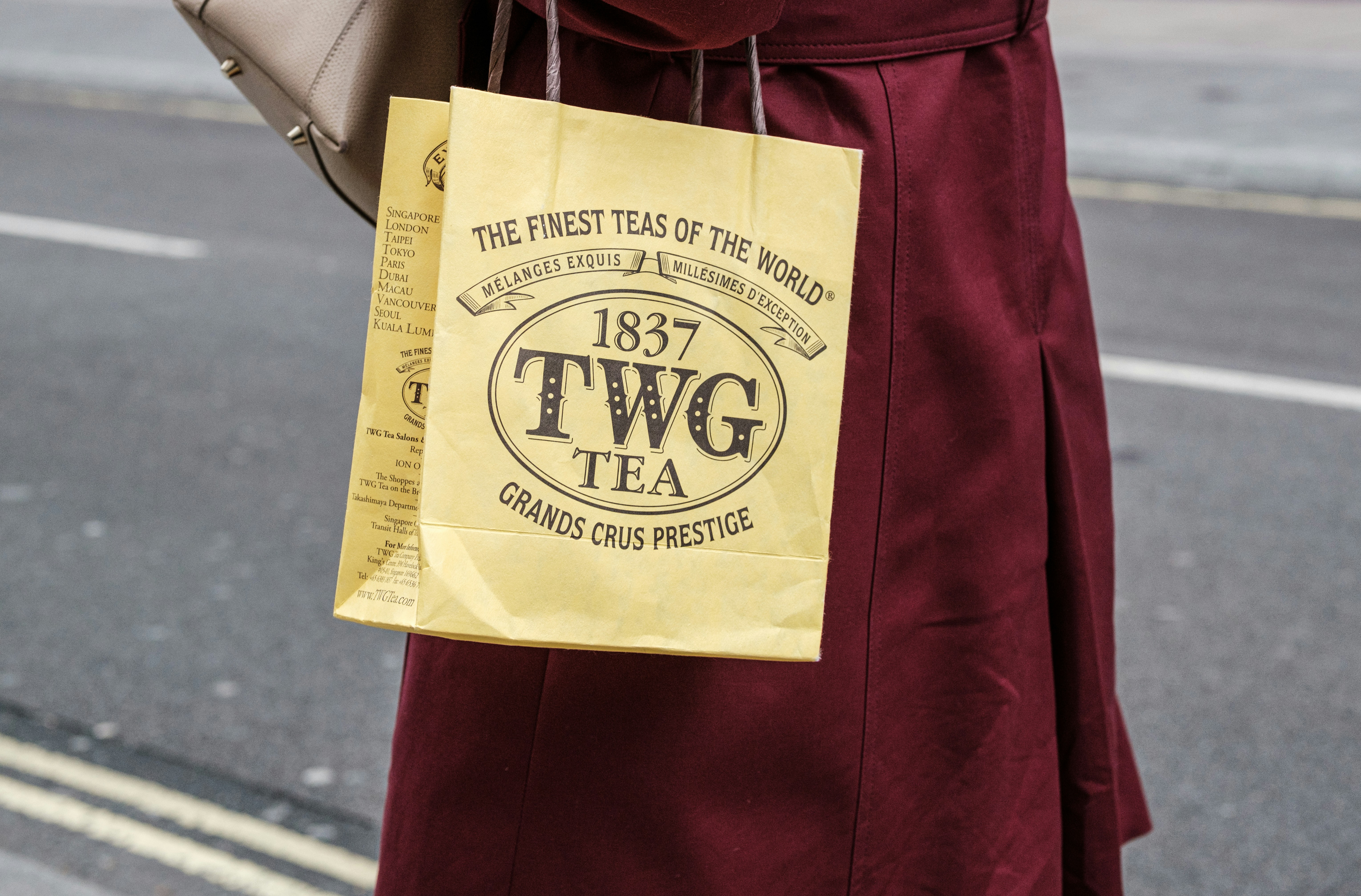 a woman in a red dress holding a brown bag