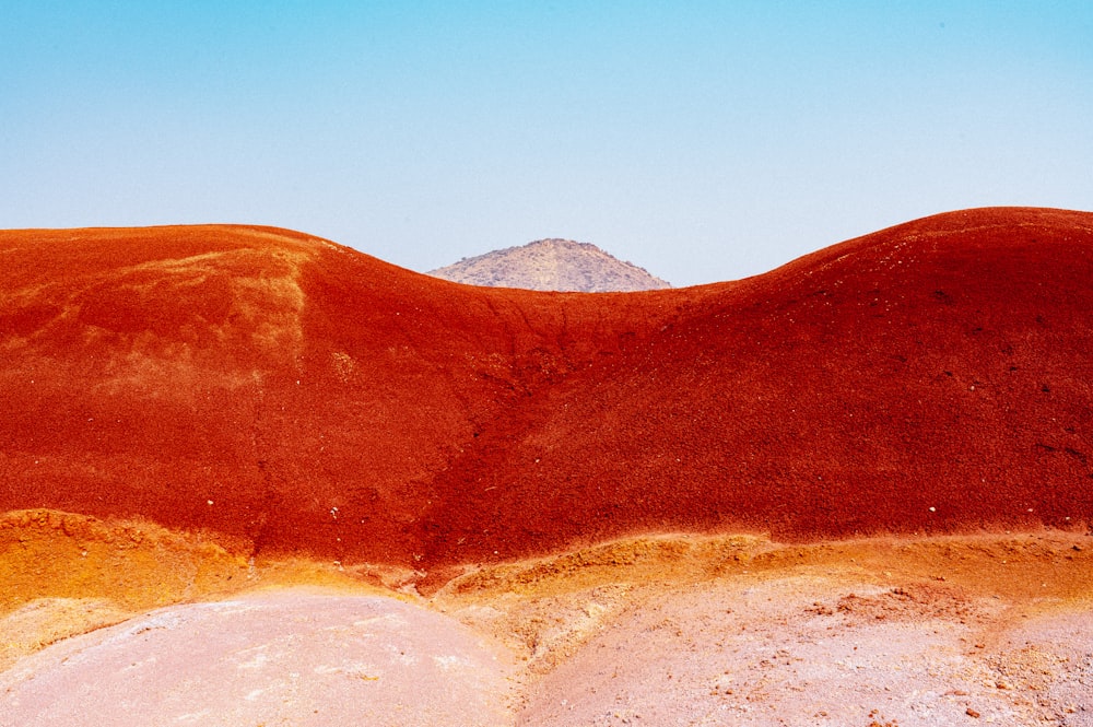 a view of a hill with a blue sky in the background