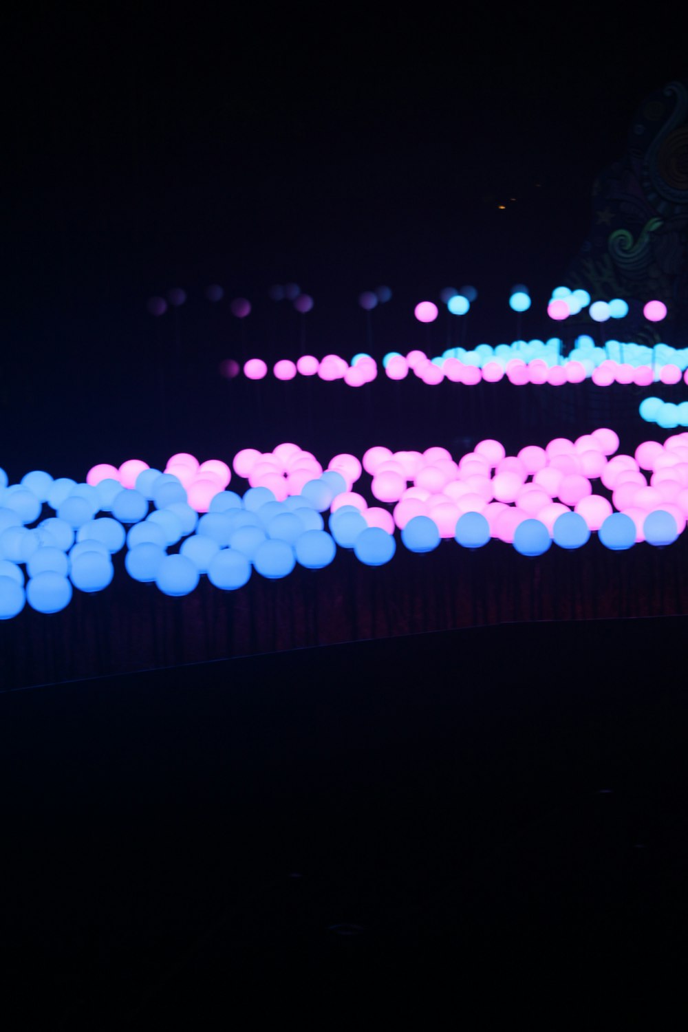 a bunch of balloons that are glowing in the dark