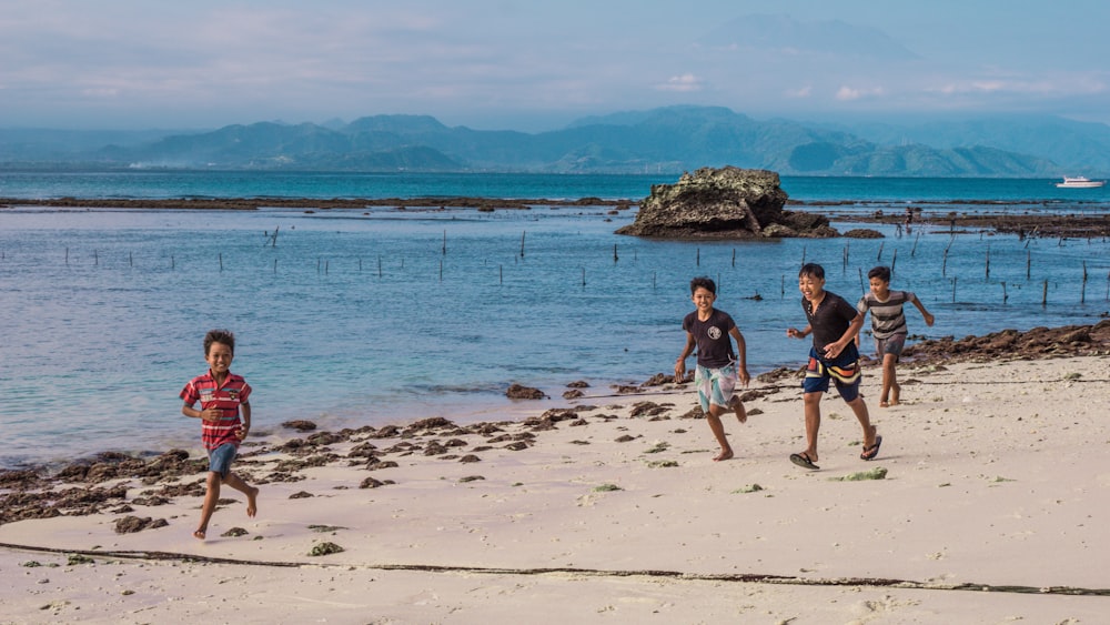 a group of kids playing soccer on the beach