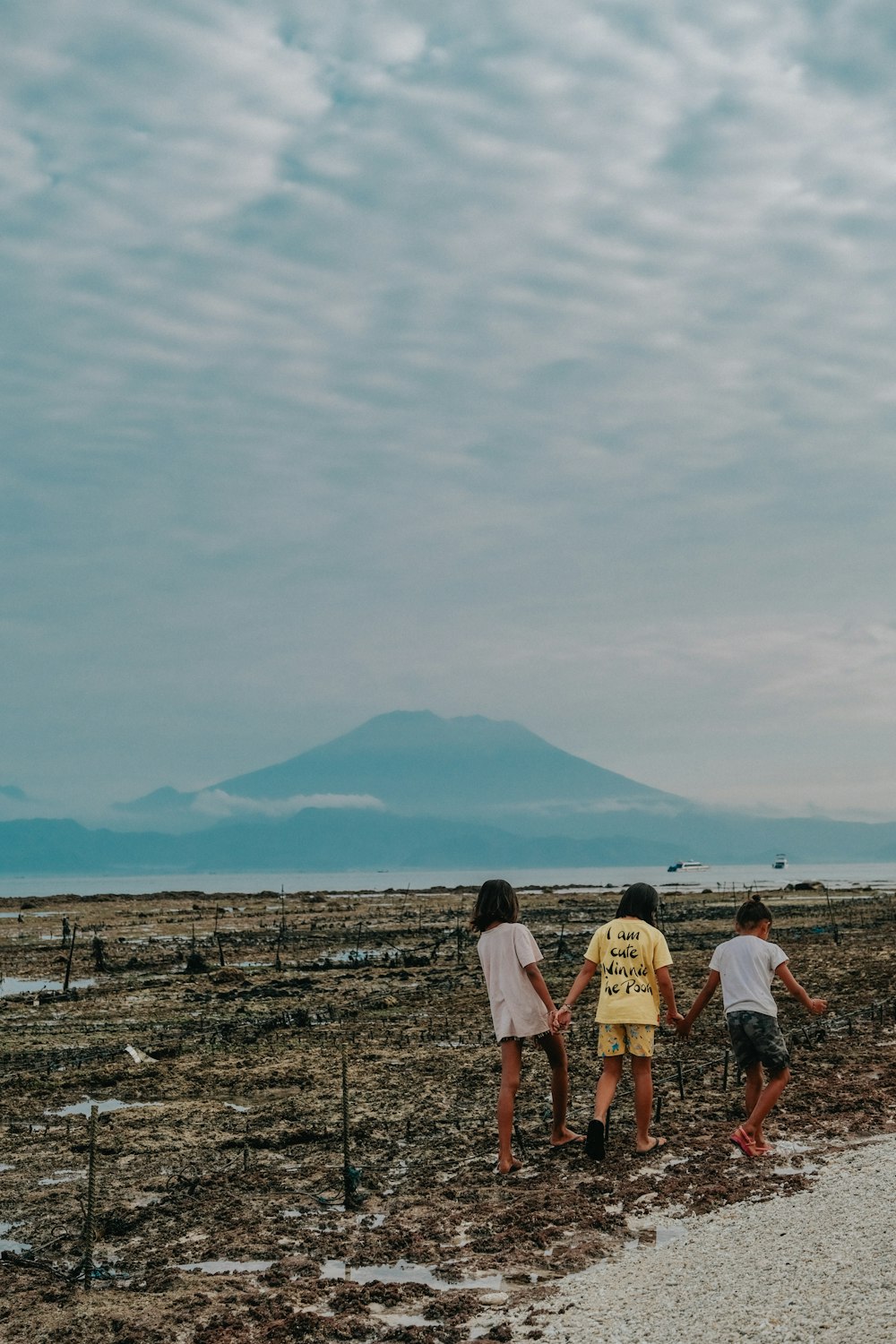 a group of people walking down a dirt road