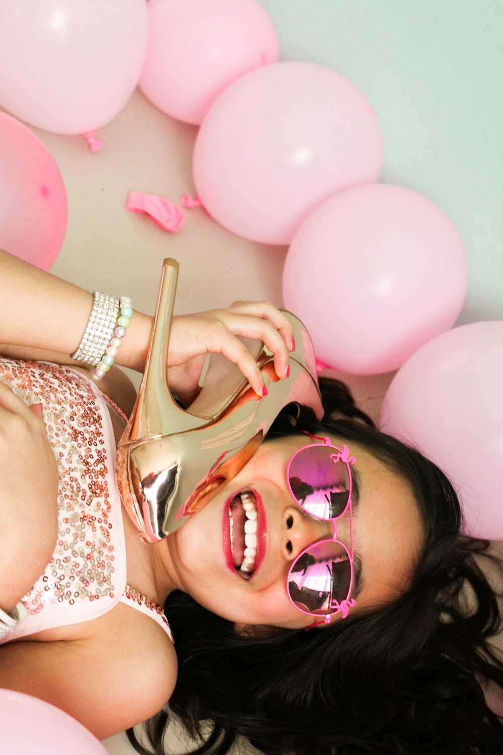 a woman laying on the ground with a pair of pink sunglasses