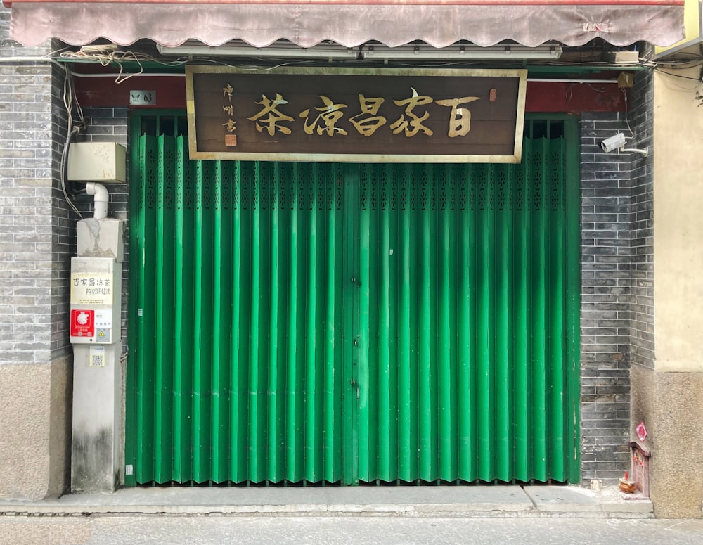 a green garage door with chinese writing on it
